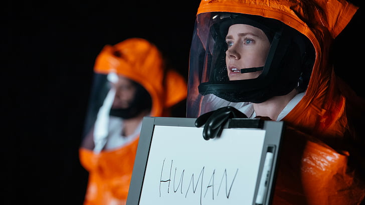 person wearing astronaut suit holding white magnetic board with human text