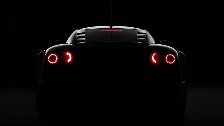 black sports car taillight, illuminated, red, studio shot, black background