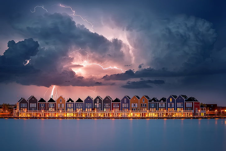 assorted-color houses with lightning from the sky panoramic photography