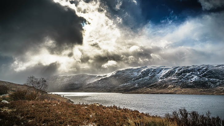 brown grasses in front of lake underneath white clouds, highlands, scotland, united kingdom, highlands, scotland, united kingdom