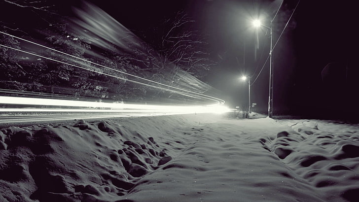 gray utility pole, timelapse photography of snow-covered pathway during night time