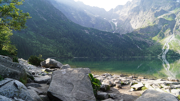 mountain range with calm body of water, green mountain under during daytime