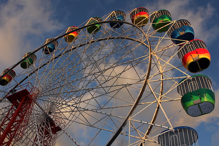 low angle photo of white, green, and blue ferris wheel under white and blue cloudy sky during daytime