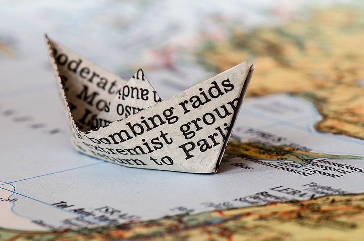 map, paper, paper boats, text, selective focus, close-up, no people