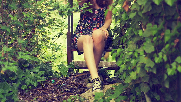 women's floral strapless dress, woman wearing black and pink floral dress sitting on bench surrounded by plants during daytime