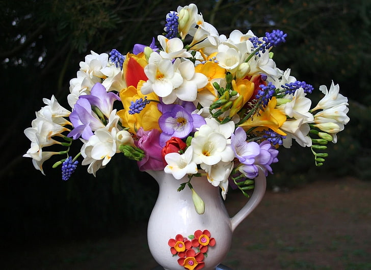 white, purple, and yellow freesia and purple grapes hyacinth flower arrangement