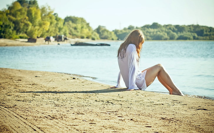woman wearing white dress shirt sitting on brown sand, women