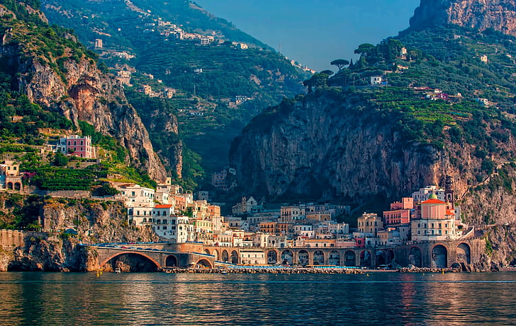 Italy city in mountains, village houses near body of water scenery