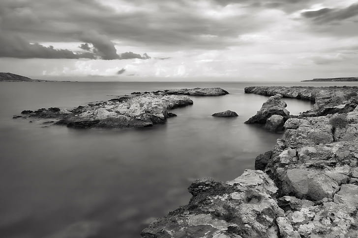 grayscale photography of rock formation near body of water, BandW
