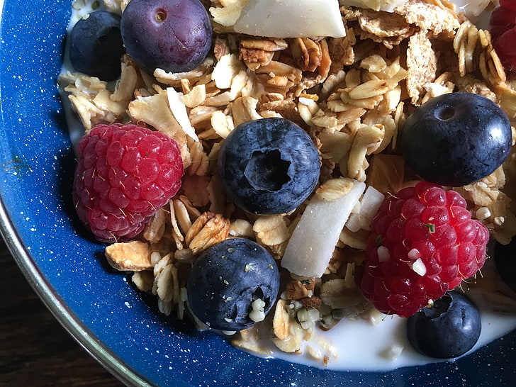 bunch of raspberries and blueberries, cereal, granola, milk, blueberry