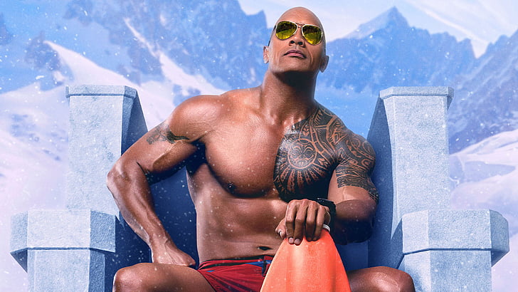Dwayne The Rock Johnson in Bay Watch sitting on gray concrete stairs holding orange safety pad