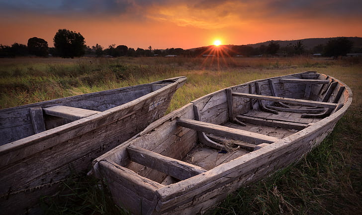 two gray wooden row boats on green grass field during dusk, tanzania, lake tanganyika, tanzania, lake tanganyika