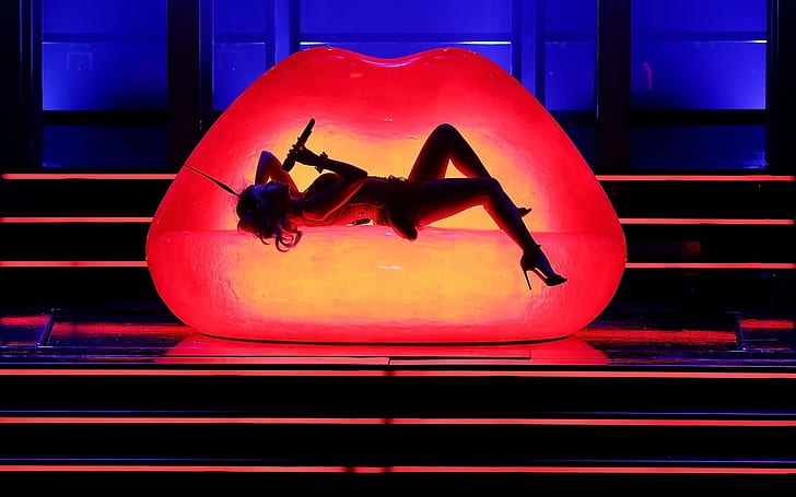 Kylie Minogue Performance, woman lying on red lips designed chair