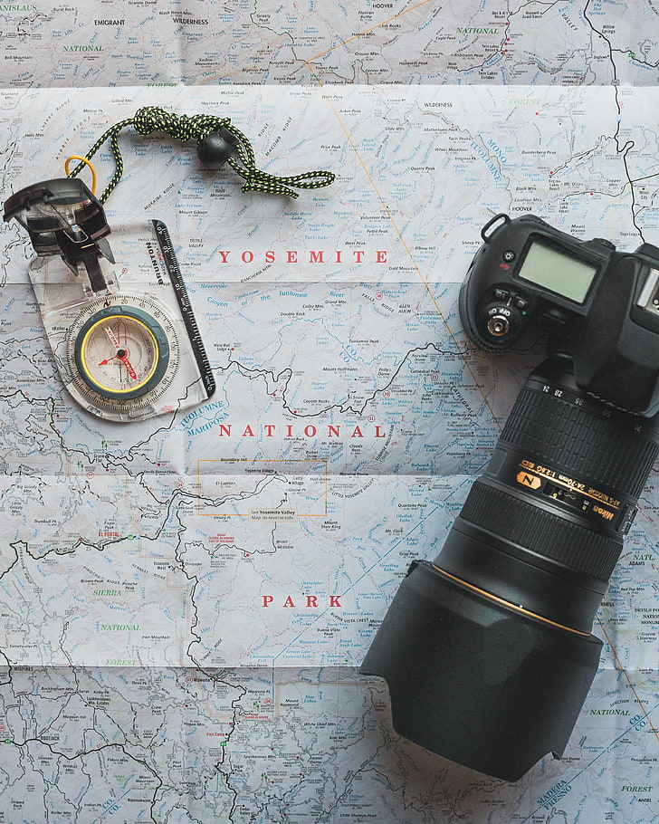 black DSLR camera and gray compass, travel, map, direction, equipment