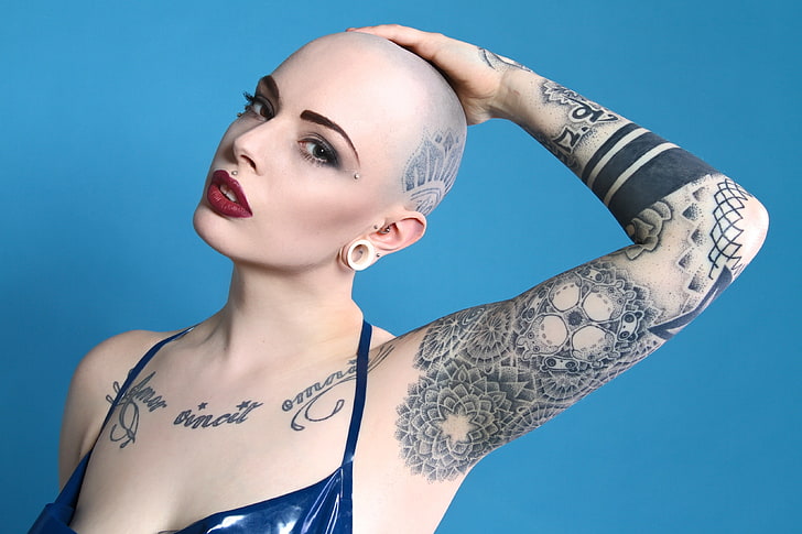 A young woman with a shaved head and tattoos on her shoulder arms and  hands Stock Photo  Alamy
