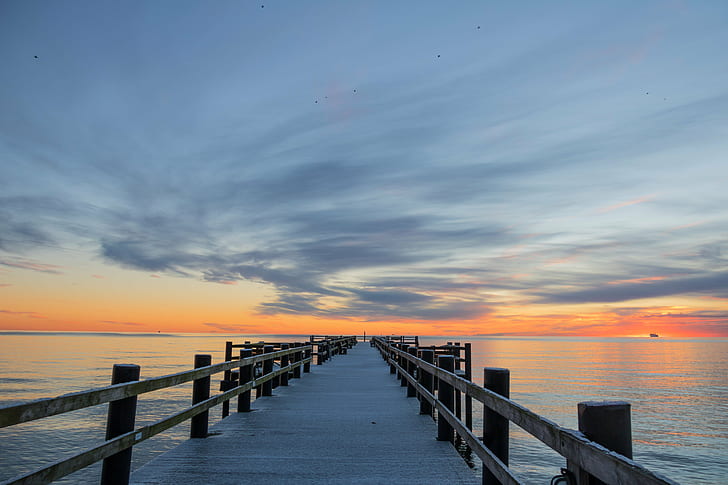 landscape photo of wooden dock with sunset as a background, cloud
