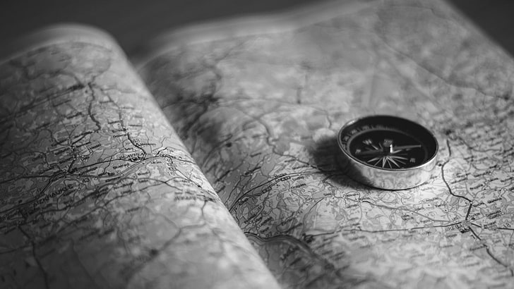 round silver compass, map, monochrome, books, direction, selective focus