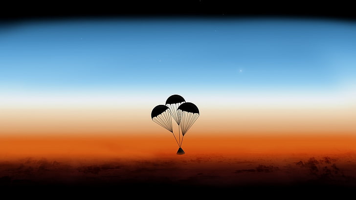 silhouette of triangular case with three parachutes during daytime