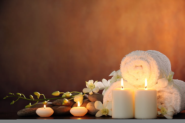 two white pillar candles, flowers, Spa, Spa stones, white Orchid
