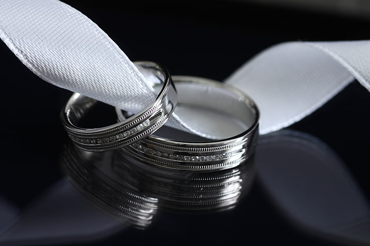 two silver-colored rings, pair, platinum, ribbon, black background