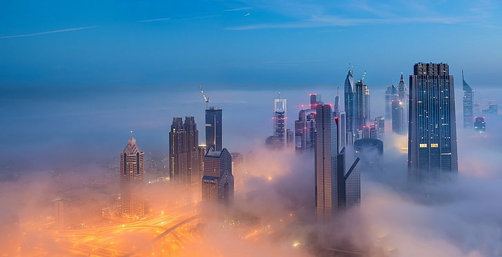 high-rise buildings covered by fog under blue sky, photography