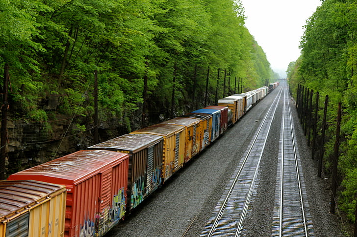 landscape photo of train on reels beside trees, railroad Track