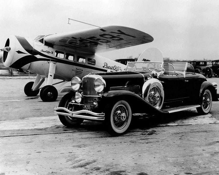classic black vehicle near airplane, old car, monochrome, mode of transportation