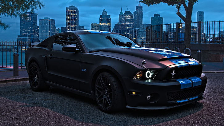 black coupe, blue and maroon Ford Mustang coupe on road during nighttime