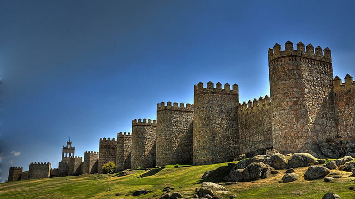 Fortress In Avila Spain, brown castle walls, towers, grass, rocks