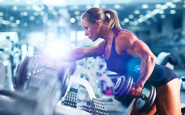 woman holding dumbbell in focus photography, muscles, blonde