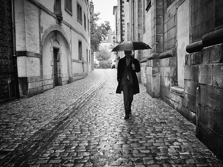 grayscale photography of man walking on hallway and holding umbrella at daytime, luxembourg, luxembourg