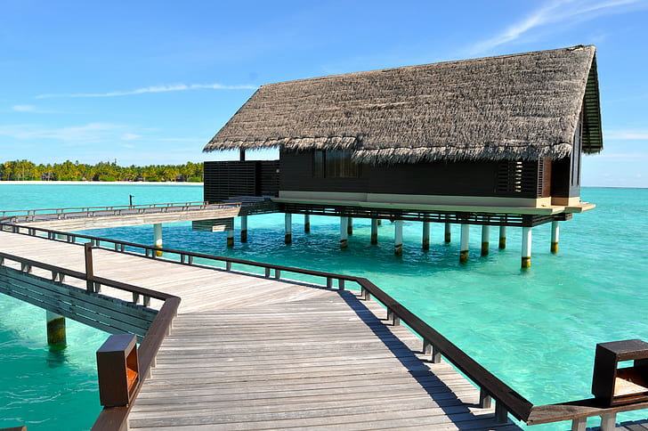 brown wooden house in body of water under blue sky, maldives, maldives