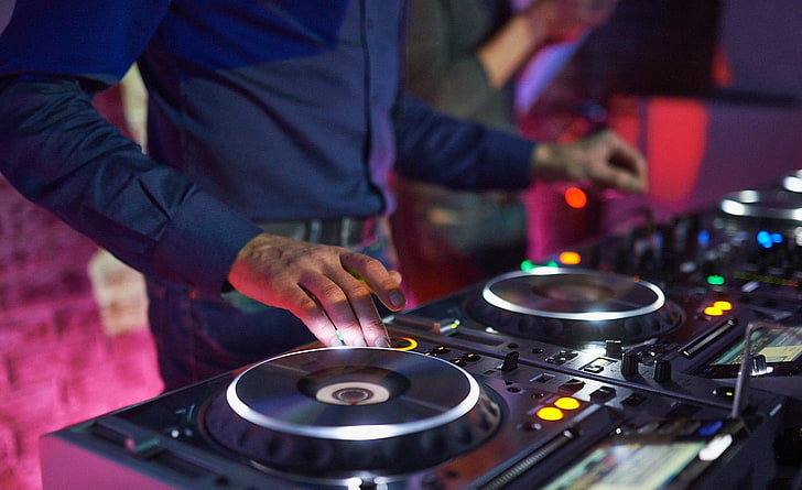 man playing DJ controller, turntables, mixing consoles, music