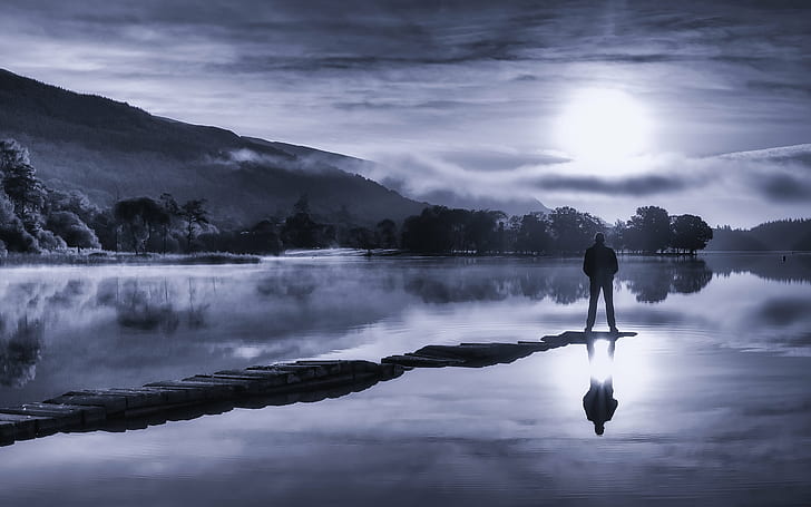 silhouette of man standing on rock near body of water, Watch