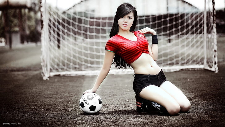 women's red crop-top and black short shorts, soccer, balls, kneeling