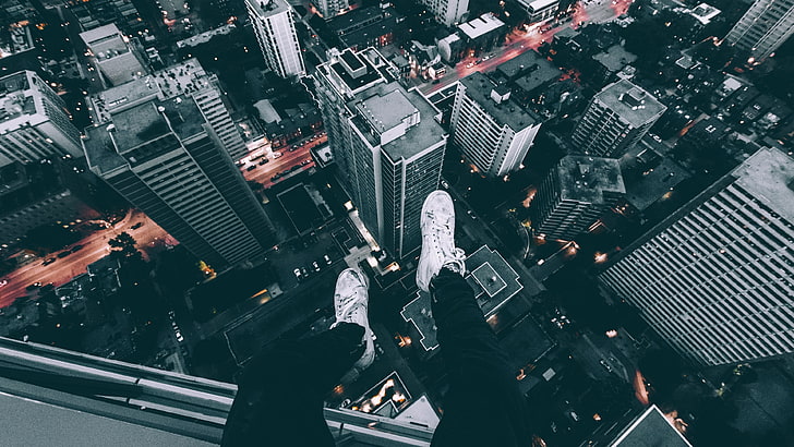 person sitting on top of high-rise building, aerial photography of metropolitan