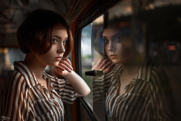 reflective photography of woman in white and brown striped top
