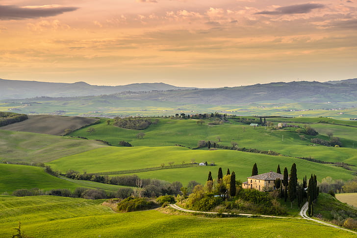 photo of yellow and brown concrete house surrounded with green trees and field of green grasses, val d'orcia, val d'orcia