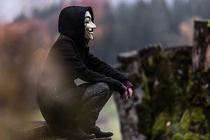 Anonymous man wearing black pullover hoodie with gray denim pants and black leather shoes sitting on brown cut log during daytime, HD wallpaper