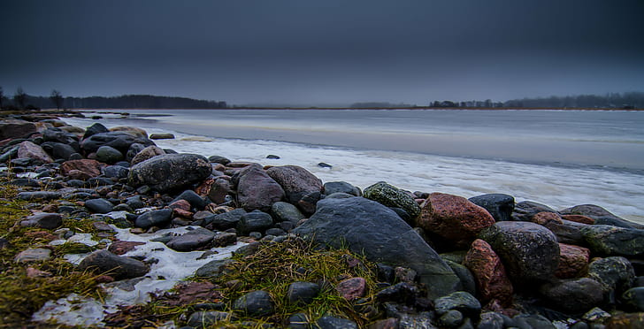 black and maroon rocks near sea shore under gary sky, finland, finland