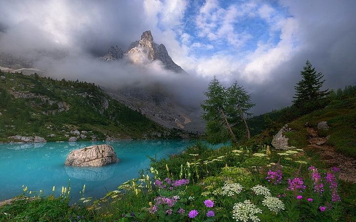 garden near blue body of water with mountain in distant, Dolomites (mountains)