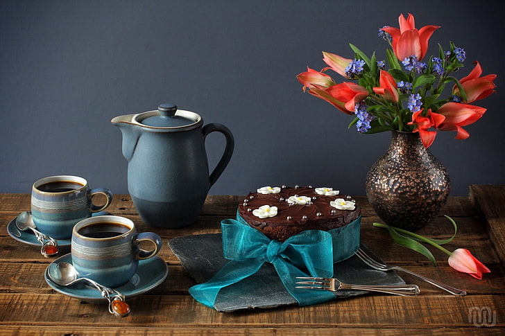 blue ceramic teapot with two teacups, bouquet, tulips, cake, still life