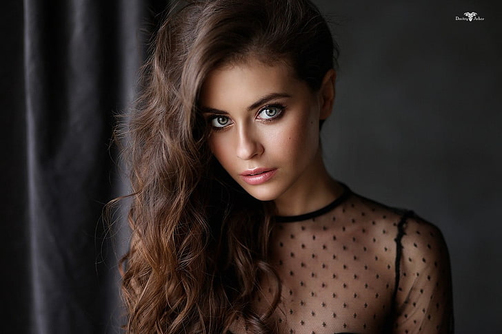 women's black illusion-neckline top, brunette, wavy hair, face