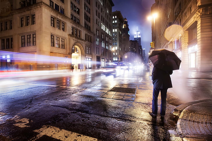 time lapse photo of person holding umbrella in middle of road during nighttime, empire, empire