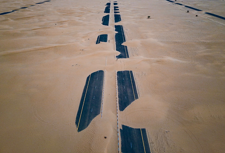 black concrete road, asphalt road covered with sand, desert, highway