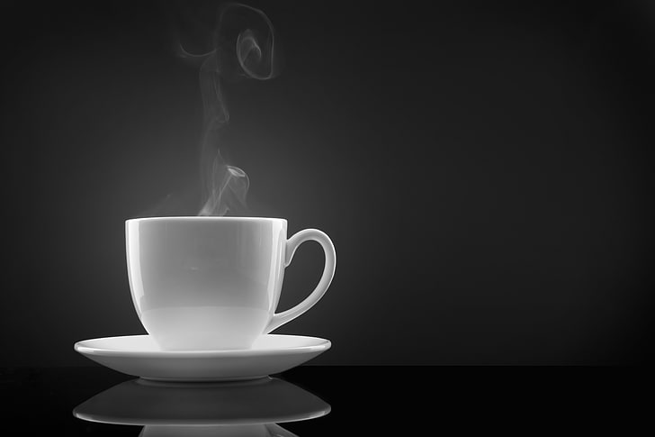 white ceramic teacup with saucer, coffee, steam, black background
