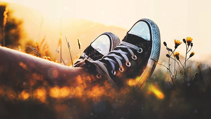 pair of black Converse All-Star low-tops, selective focus, sunset