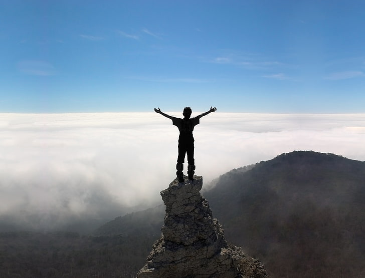 man standing on mountain peak in silhouette photography, people