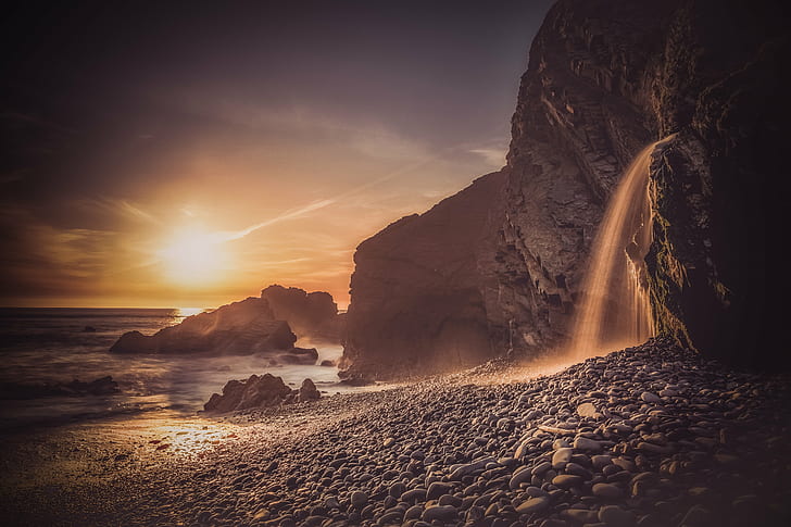 waterfalls on rocky mountain near seashore during sunset, bude