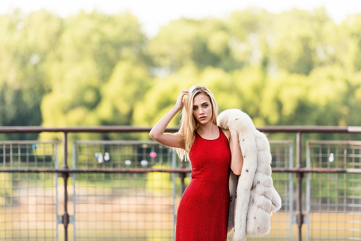 woman wearing red sleeveless bodycon dress holding white coat